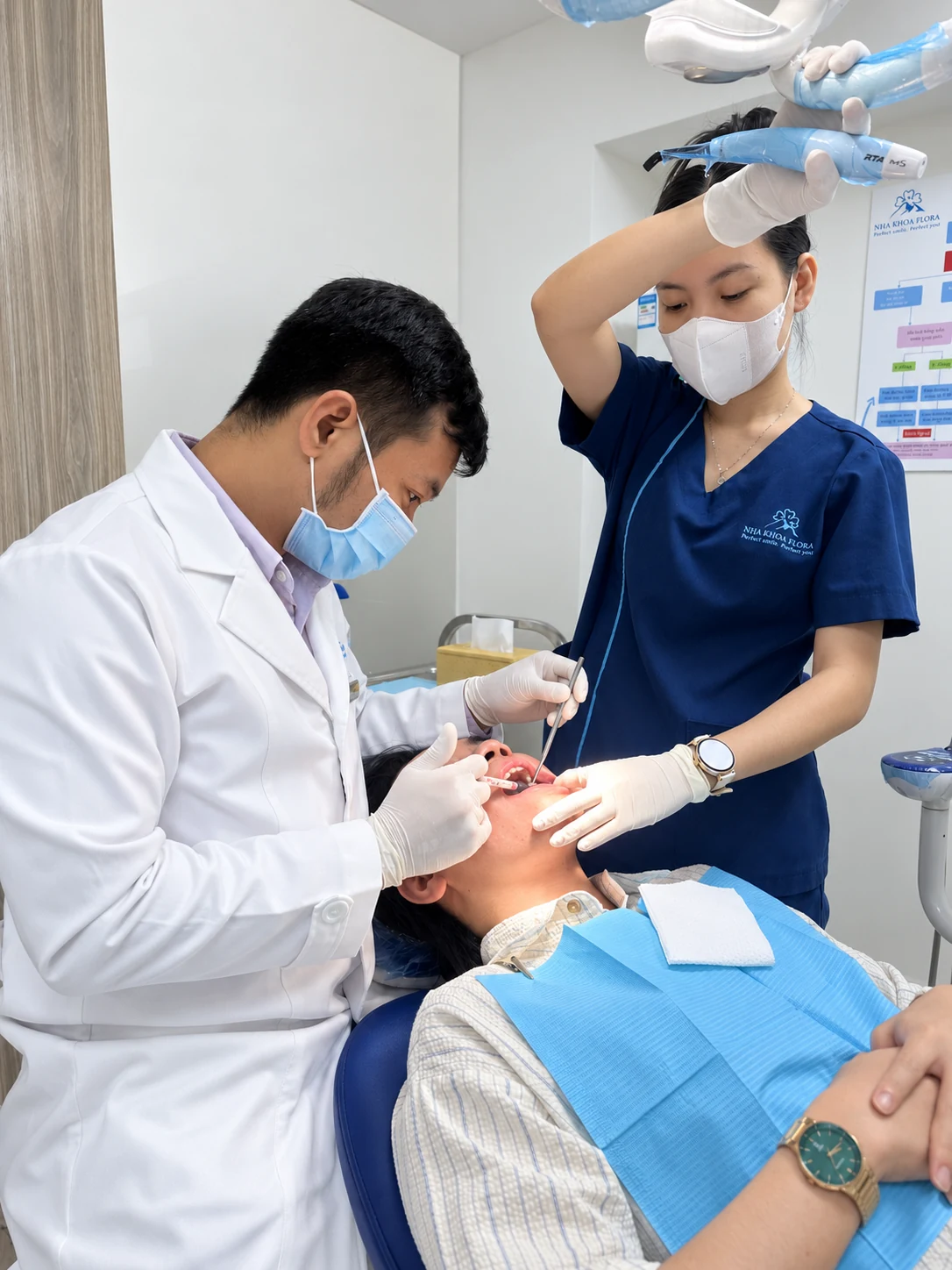 Bác sĩ Minh cùng phụ tá chăm sóc và tái khám cho bệnh nhân trên ghế nha khoa